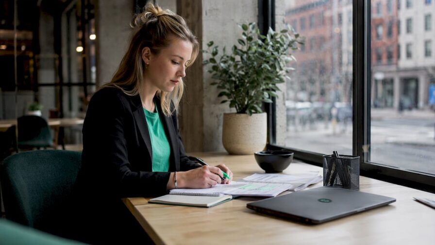Een recruiter zit aan zijn bureau en beoordeelt binnengekomen cv’s.