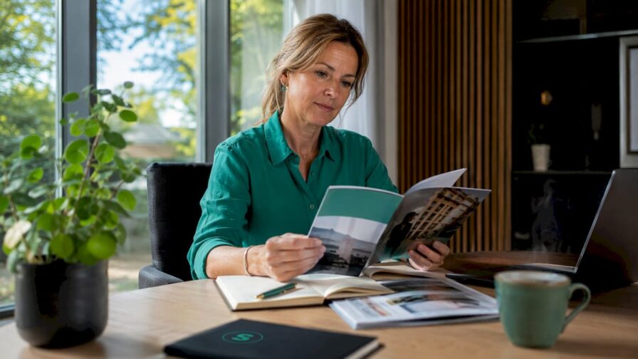 Vrouw bladert thuis door een wervingsbrochure voor een functie op afstand
