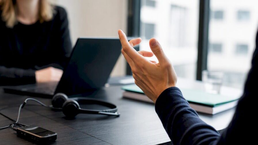 Handgebaar dat een coachingsaanpassing aangeeft tijdens een sollicitatiegesprek rollenspel