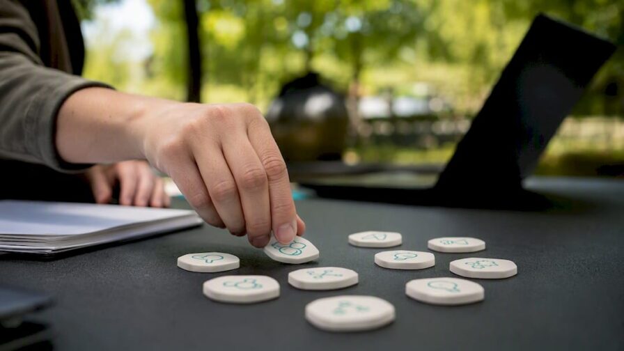 Hand legt vaardigheidskaartjes op bureau neer