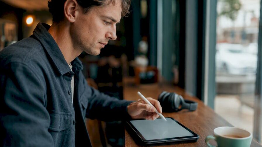 Hand met pen op een digitale tablet op kantoor